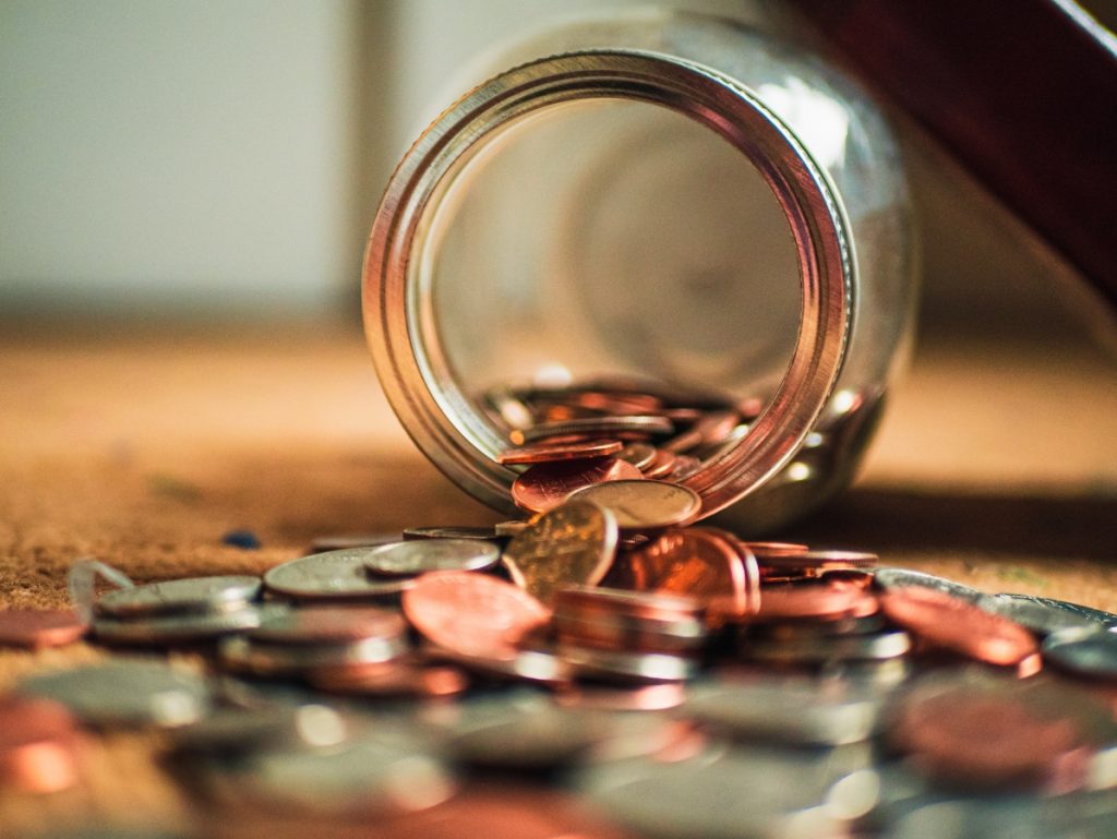 Coins spilling out of a jar money saved with fleet solutions