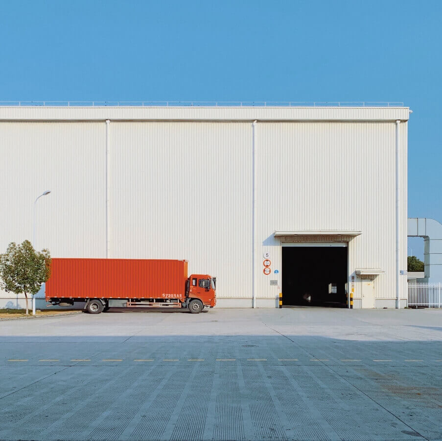 orange truck in front of wharehouse