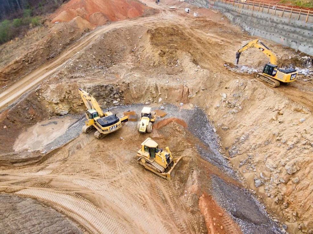 construction site with four construction vehicles equiped with digger trackers