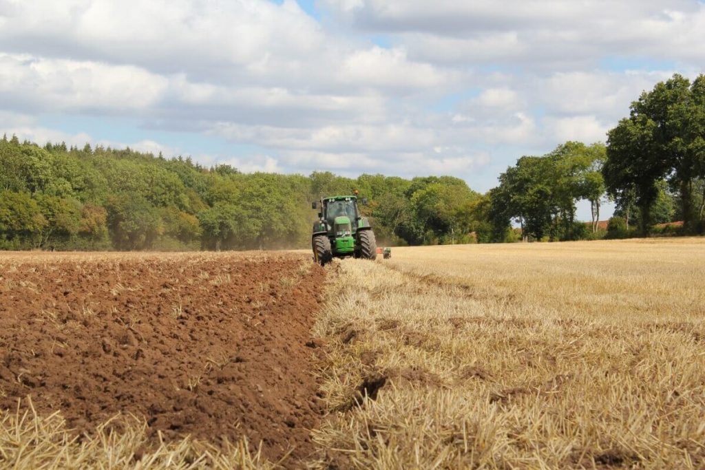 Tractor working through farm on sunny day with tractor GPS