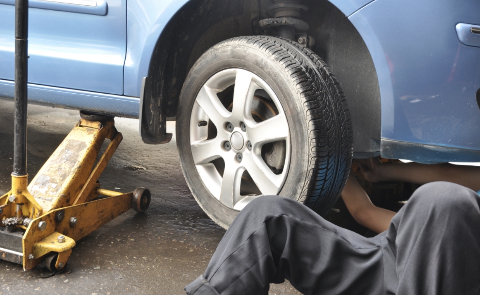 Employee fixing a car using an OBD GPS Tracker