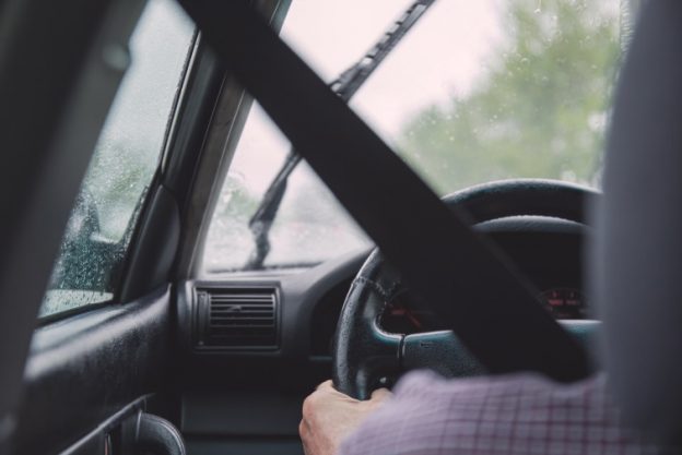 Person sitzt am Steuer eines Autos.